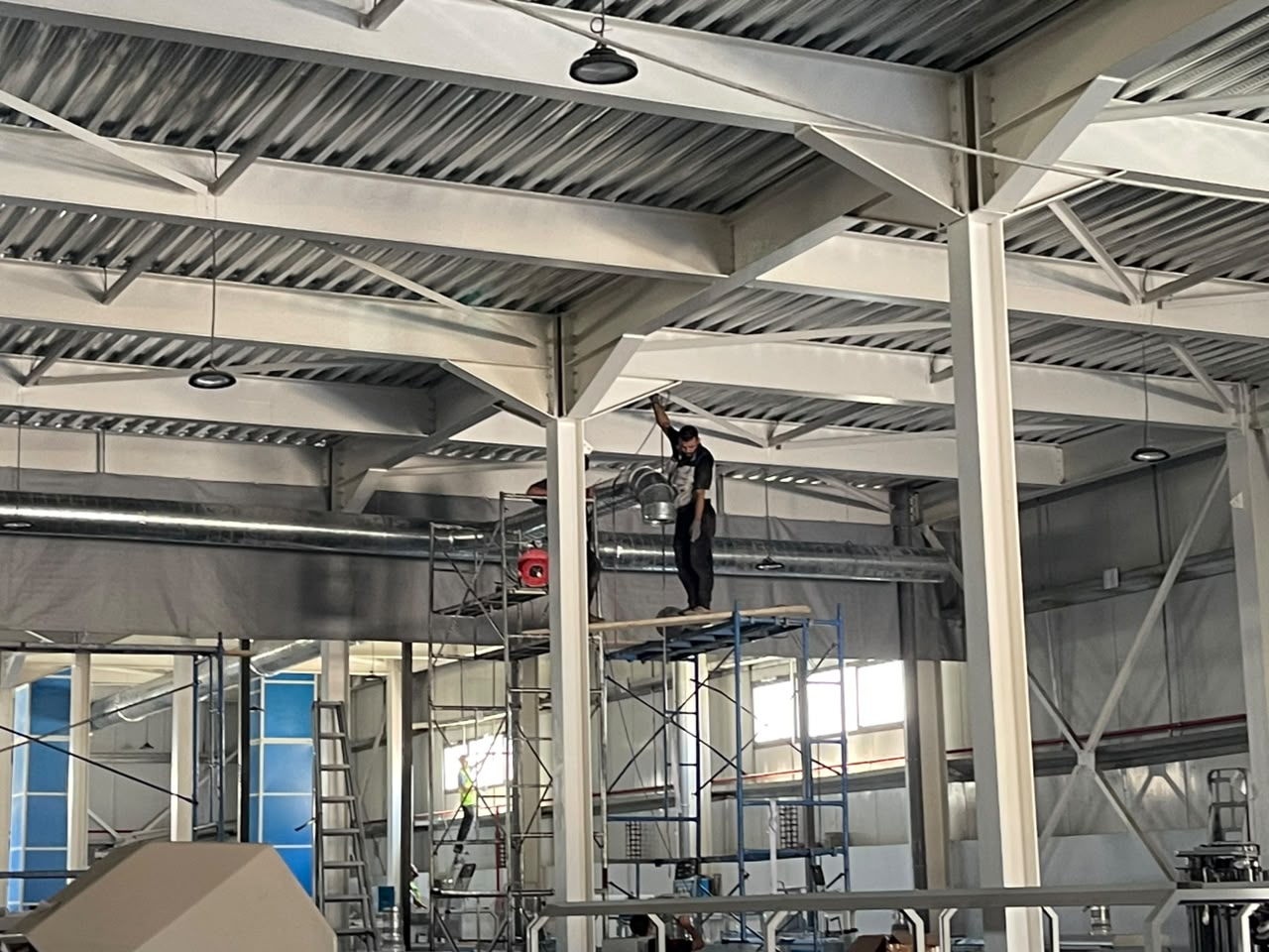Pose de gaine circulaire en hall industriel